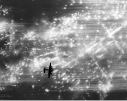 El perfil de un bombardero británico se recorta sobre Dresde en llamas.